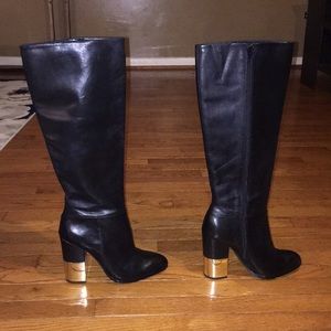 Under the knee black boots with gold heel